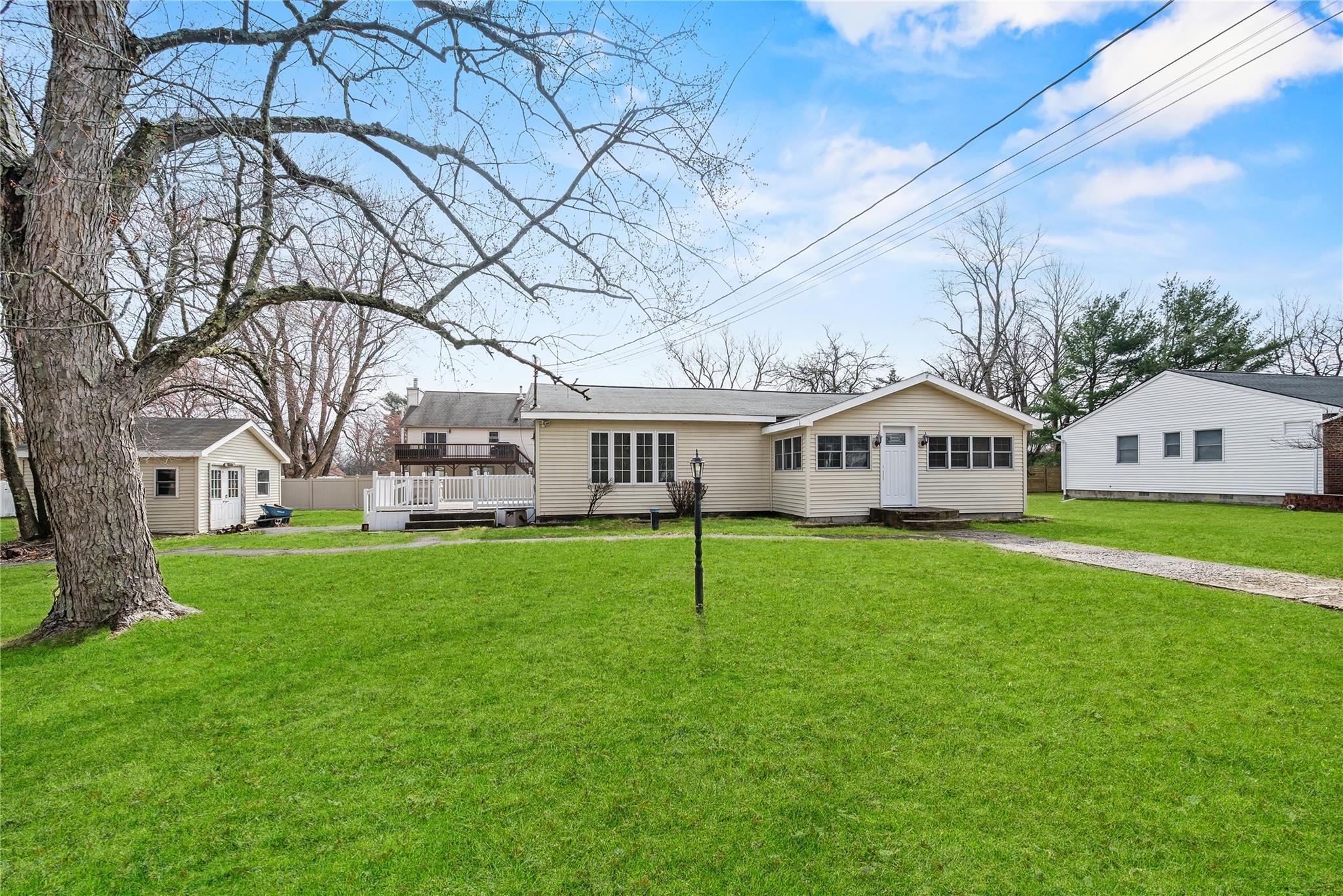 a front view of a house with a yard and trees