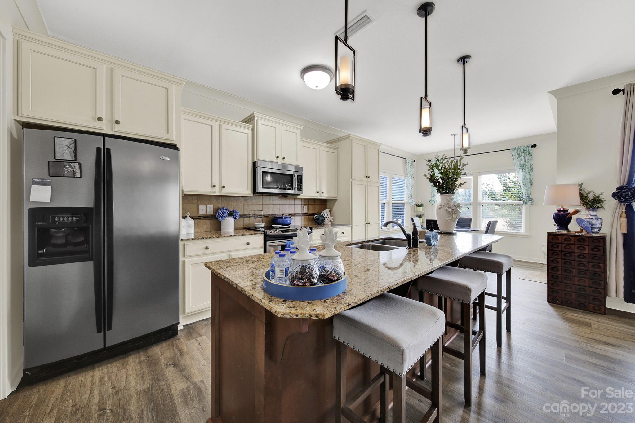 25554 Seagull Drive Lancaster, SC 29720 - Photo 14 of 33 a kitchen with refrigerator a sink a stove and chairs with wooden floor