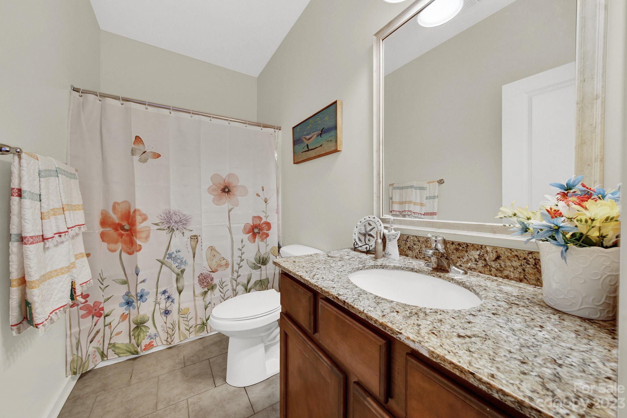 25554 Seagull Drive Lancaster, SC 29720 - Photo 8 of 33 a bathroom with a granite countertop sink a toilet and shower curtain