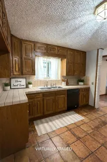 a kitchen with a sink a stove cabinets and a window