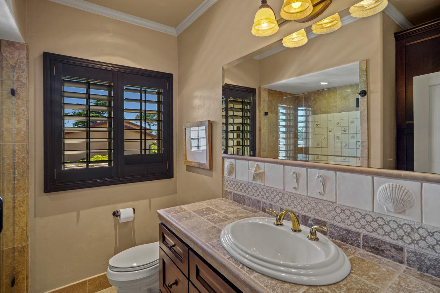 3017 Cormorant Road Pebble Beach, CA 93953 - Photo 23 of 42 a bathroom with a granite countertop sink and a mirror