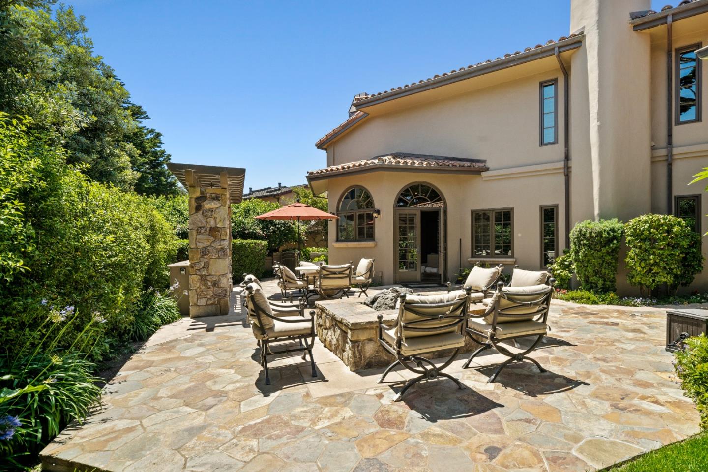 3017 Cormorant Road Pebble Beach, CA 93953 - Photo 35 of 42 a view of a patio with table and chairs potted plants and floor to ceiling window