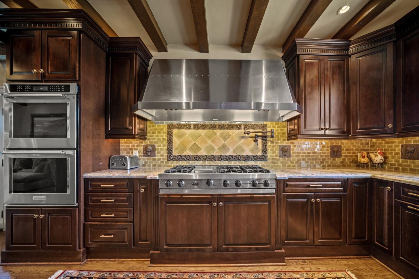 3017 Cormorant Road Pebble Beach, CA 93953 - Photo 8 of 42 a kitchen with stainless steel appliances wooden cabinets and a stove top oven