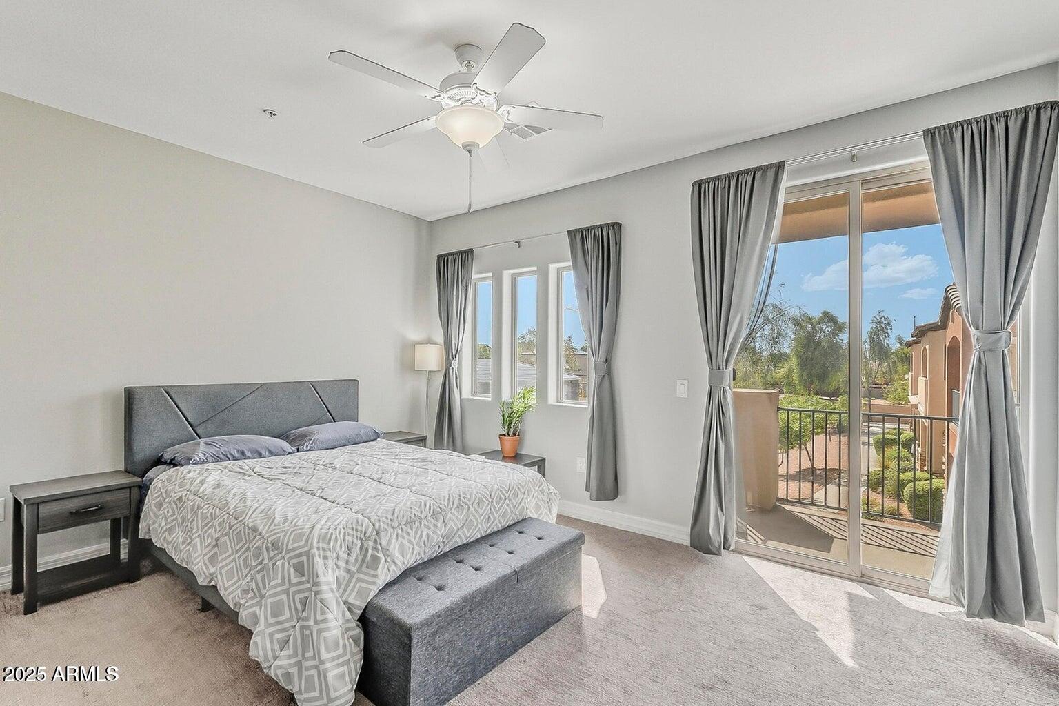 2821 South Skyline Drive, Unit 141 Mesa, AZ 85212 - Photo 19 of 68 a bedroom with a large bed and a chandelier