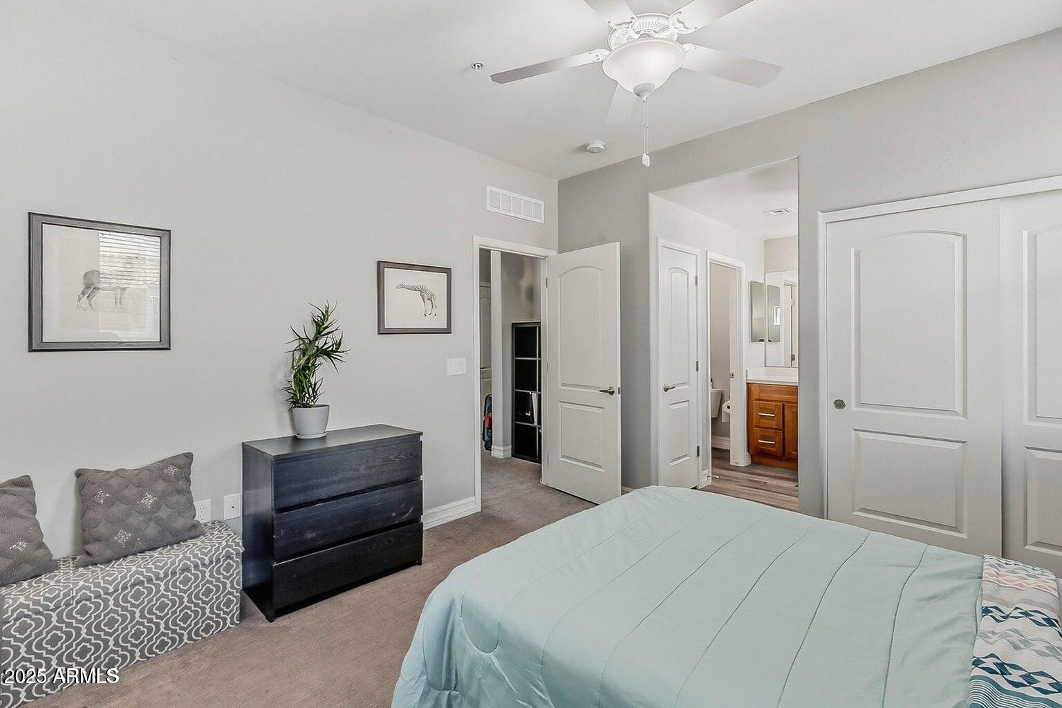 2821 South Skyline Drive, Unit 141 Mesa, AZ 85212 - Photo 29 of 68 a spacious bedroom with a bed and a chandelier