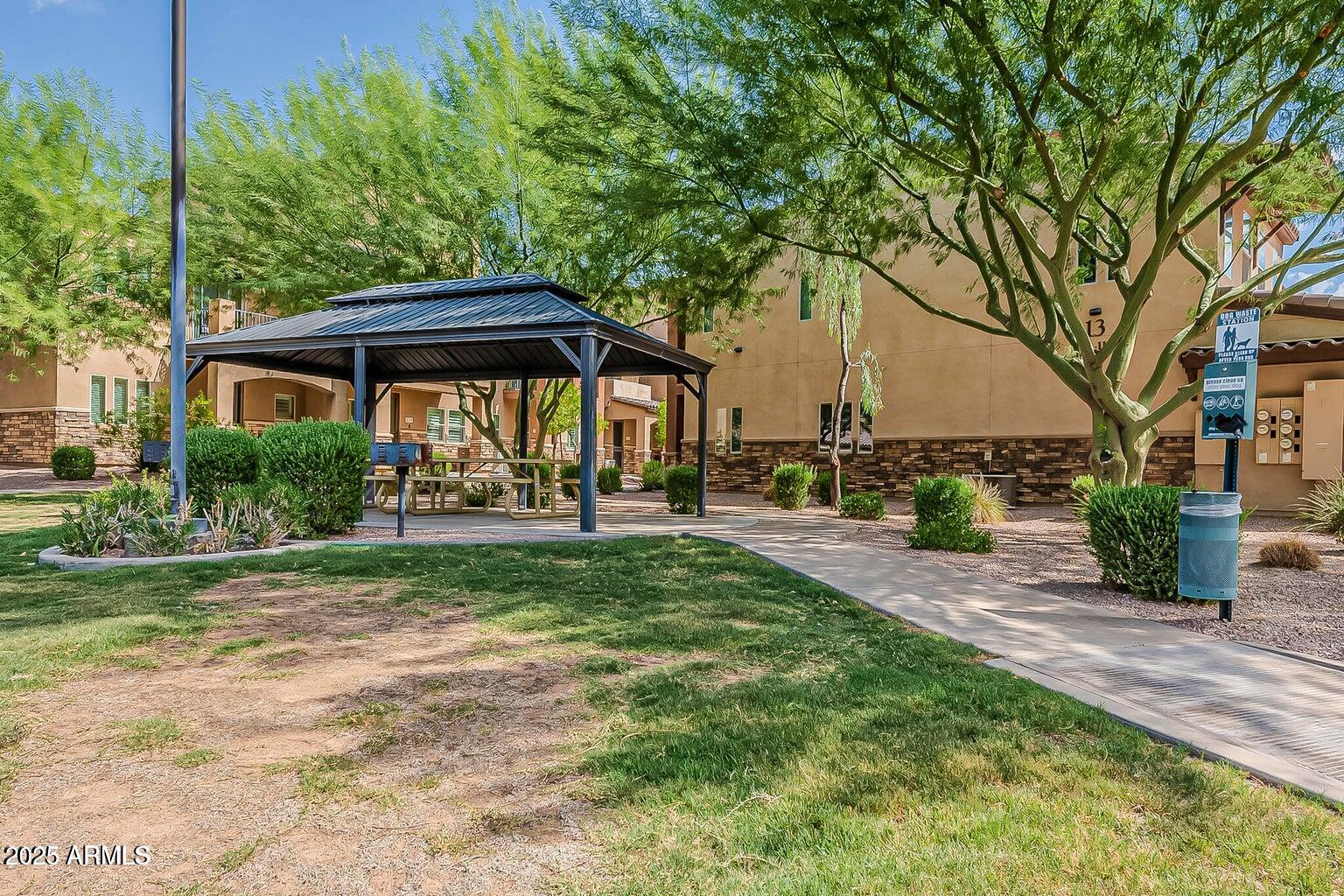 2821 South Skyline Drive, Unit 141 Mesa, AZ 85212 - Photo 44 of 68 a view of a patio with table and chairs under an umbrella