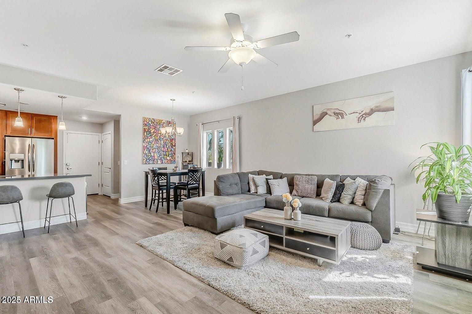 2821 South Skyline Drive, Unit 141 Mesa, AZ 85212 - Photo 5 of 68 a living room with furniture and a chandelier