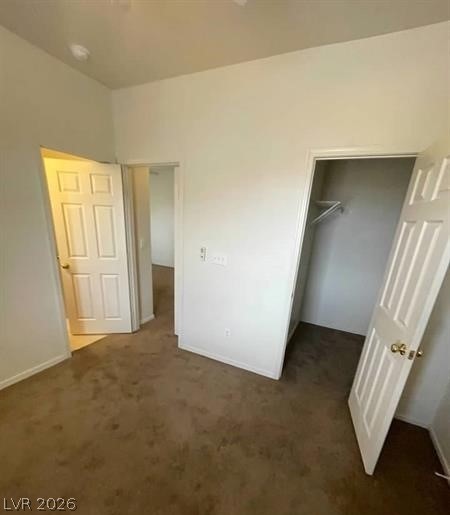 677 Principle Point Avenue Henderson, NV 89012 - Photo 11 of 40 Unfurnished bedroom featuring a walk in closet and dark colored carpet