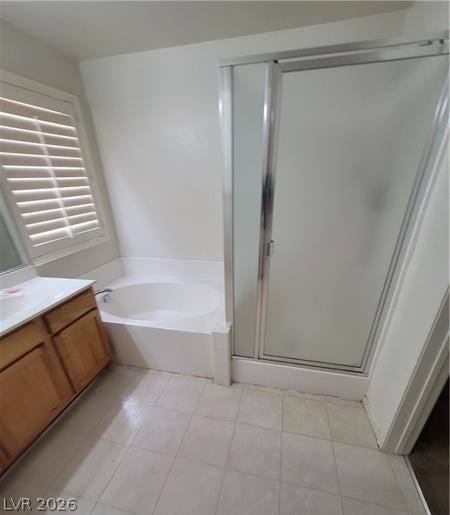 677 Principle Point Avenue Henderson, NV 89012 - Photo 15 of 40 Full bathroom featuring a stall shower, a garden tub, vanity, and light tile patterned flooring