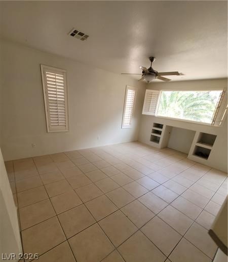 677 Principle Point Avenue Henderson, NV 89012 - Photo 4 of 40 Spare room with light tile patterned floors, ceiling fan, and healthy amount of natural light