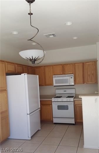 677 Principle Point Avenue Henderson, NV 89012 - Photo 5 of 40 Kitchen with white appliances, light tile patterned floors, light countertops, and hanging light fixtures
