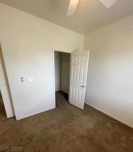 677 Principle Point Avenue Henderson, NV 89012 - Photo 10 of 40 Unfurnished bedroom featuring dark colored carpet, a walk in closet, and ceiling fan