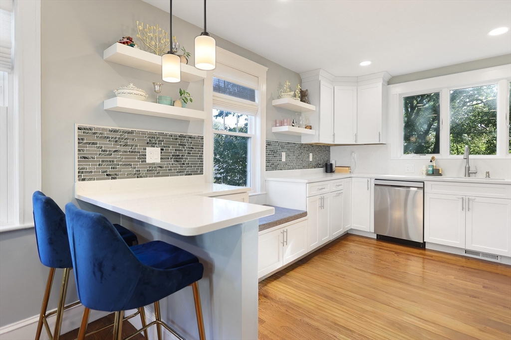 a kitchen with a wooden floor and white cabinets