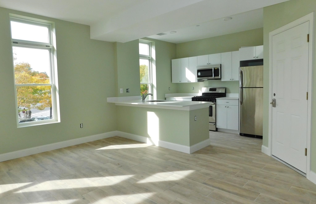 10 Roxbury Street, Unit 8 Boston, MA 02119 - Photo 7 of 10 a kitchen with stainless steel appliances granite countertop a stove a sink and a refrigerator