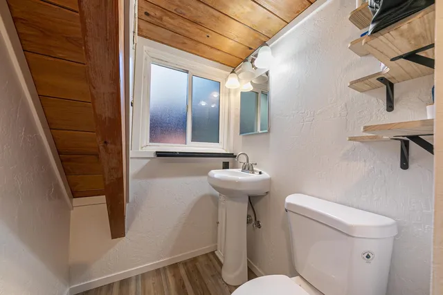 a bathroom with a sink a toilet a mirror and vanity