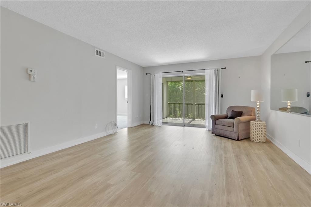 5499 Rattlesnake Hamm Road, Unit 2 Naples, FL 34113 - Photo 11 of 34 a living room with furniture and a large window