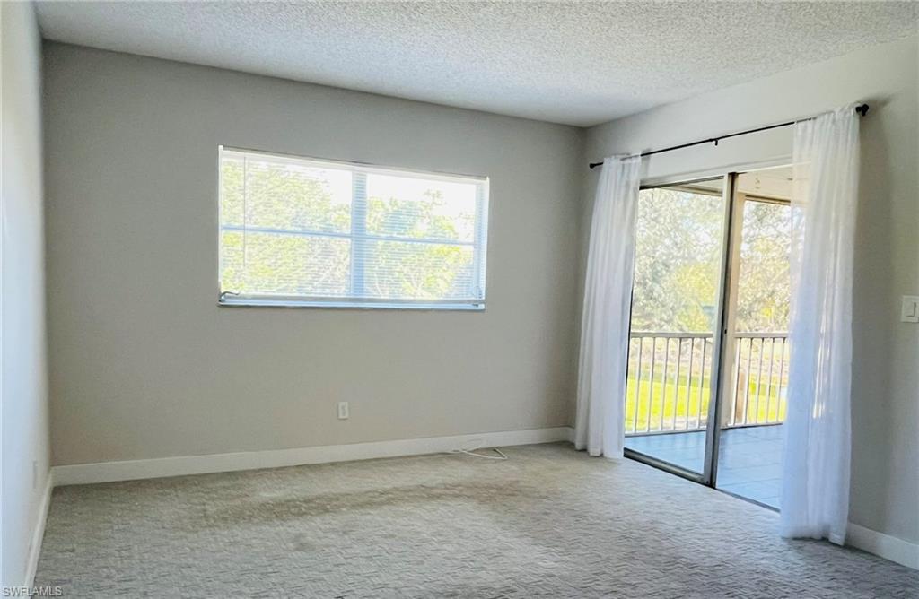 5499 Rattlesnake Hamm Road, Unit 2 Naples, FL 34113 - Photo 14 of 23 Primary bedroom with carpet flooring and a textured ceiling
