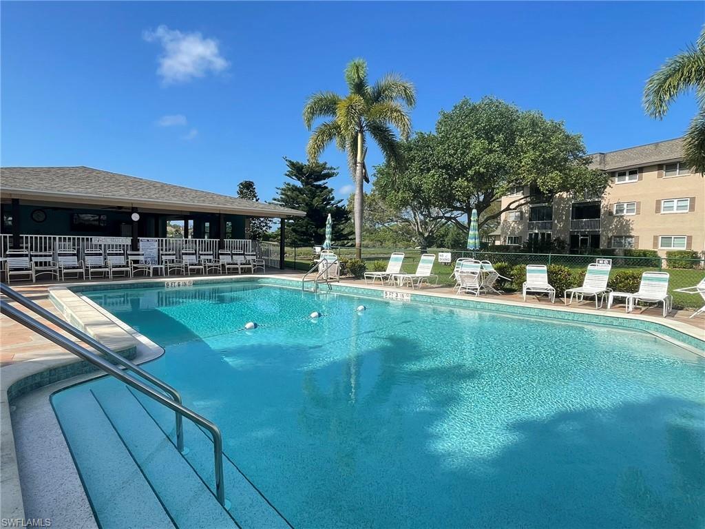5499 Rattlesnake Hamm Road, Unit 2 Naples, FL 34113 - Photo 32 of 34 a view of a swimming pool with a table and chairs