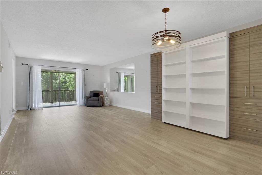 5499 Rattlesnake Hamm Road, Unit 2 Naples, FL 34113 - Photo 7 of 34 a view of a room with a large window and wooden floor
