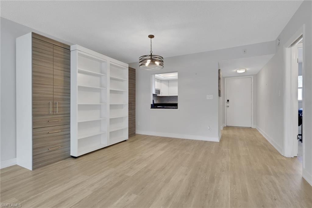 5499 Rattlesnake Hamm Road, Unit 2 Naples, FL 34113 - Photo 8 of 34 wooden floor in an empty room with a window