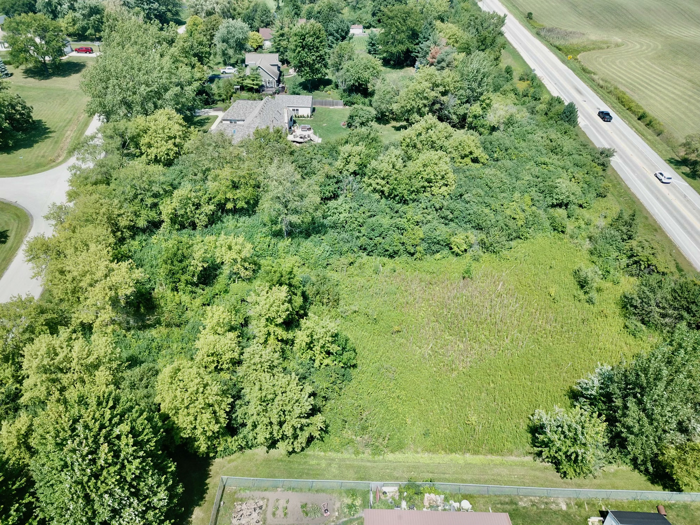 6510 Suttondale Road Huntley, IL 60142 - Photo 2 of 5 a view of a yard with plants and large trees