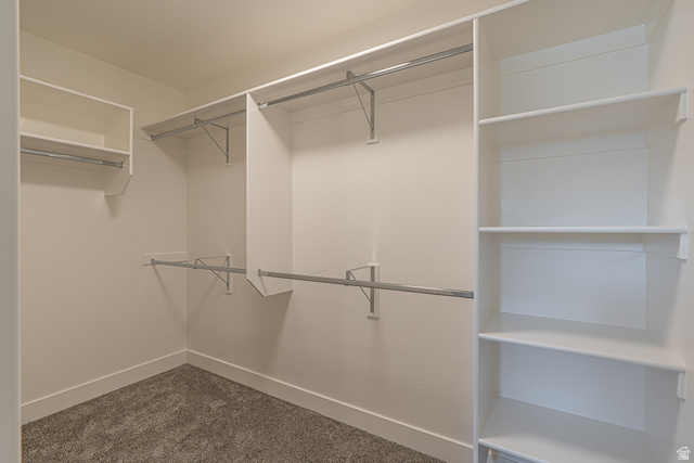 2249 South 1090 West, Unit 76 Nibley, UT 84321 - Photo 19 of 19 Walk-in closet featuring white built-in shelving, multiple hanging rods, and neutral carpet flooring