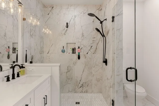 a bathroom with a sink vanity mirror and shower