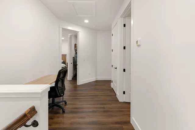 a view of a hallway with wooden floor and staircase