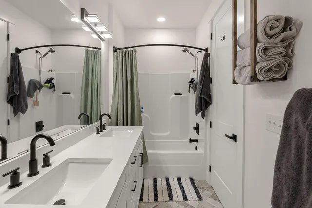 a bathroom with a sink a mirror and a shower