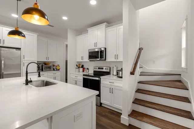 a kitchen with a sink a stove and cabinets