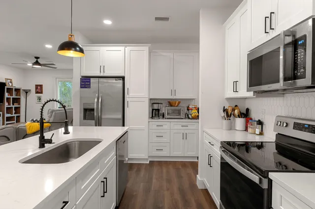 a kitchen with stainless steel appliances granite countertop a sink stove and refrigerator