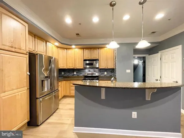a kitchen with stainless steel appliances granite countertop a sink a stove and refrigerator