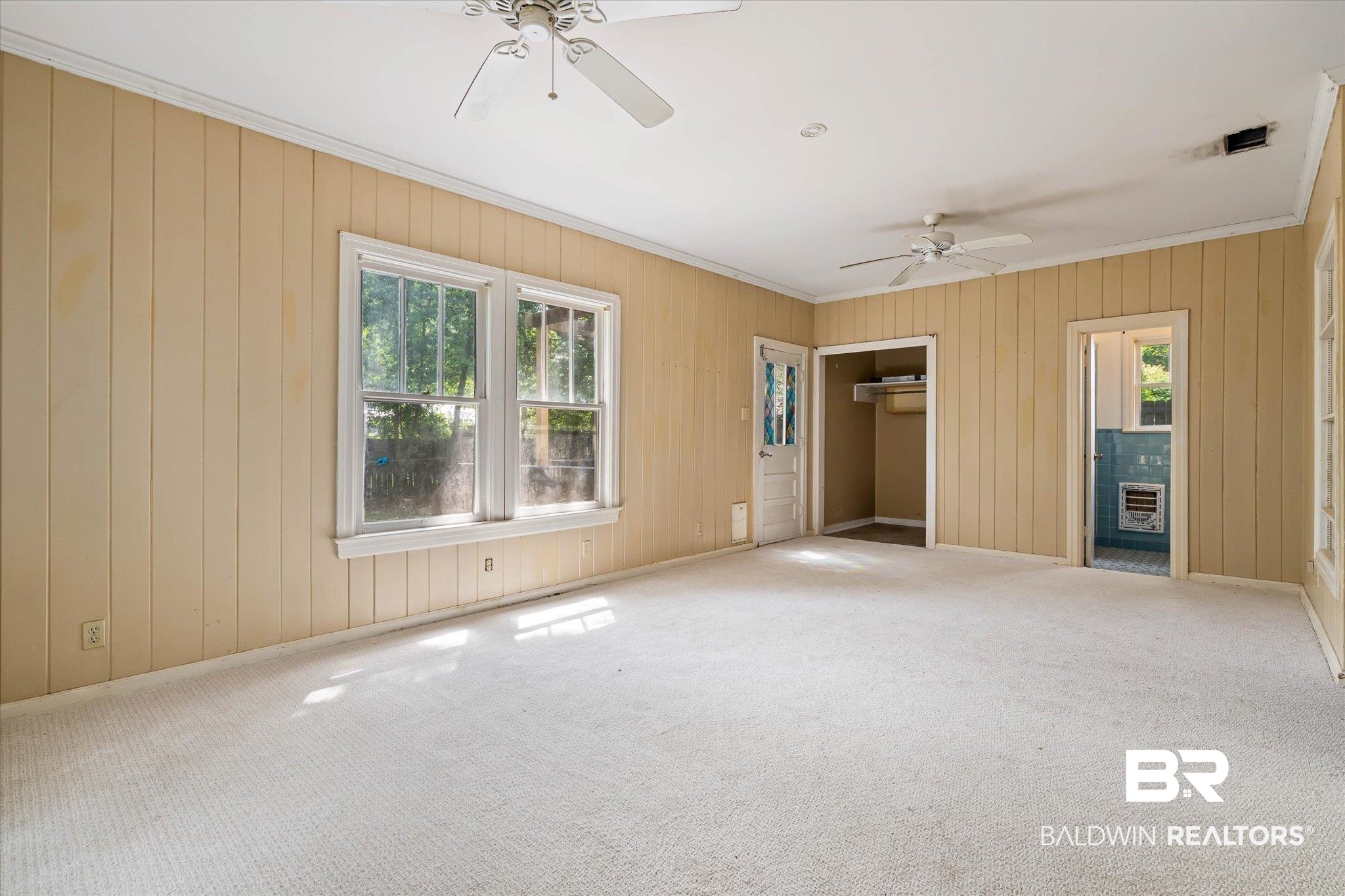 121 Westwood Street Mobile, AL 36606 - Photo 9 of 20 Unfurnished bedroom with wooden walls, carpet, crown molding, and a ceiling fan