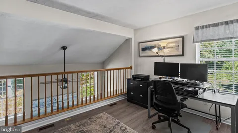 a view of a workspace with furniture and a window