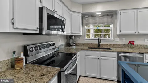 a kitchen with stainless steel appliances granite countertop a sink stove and cabinets
