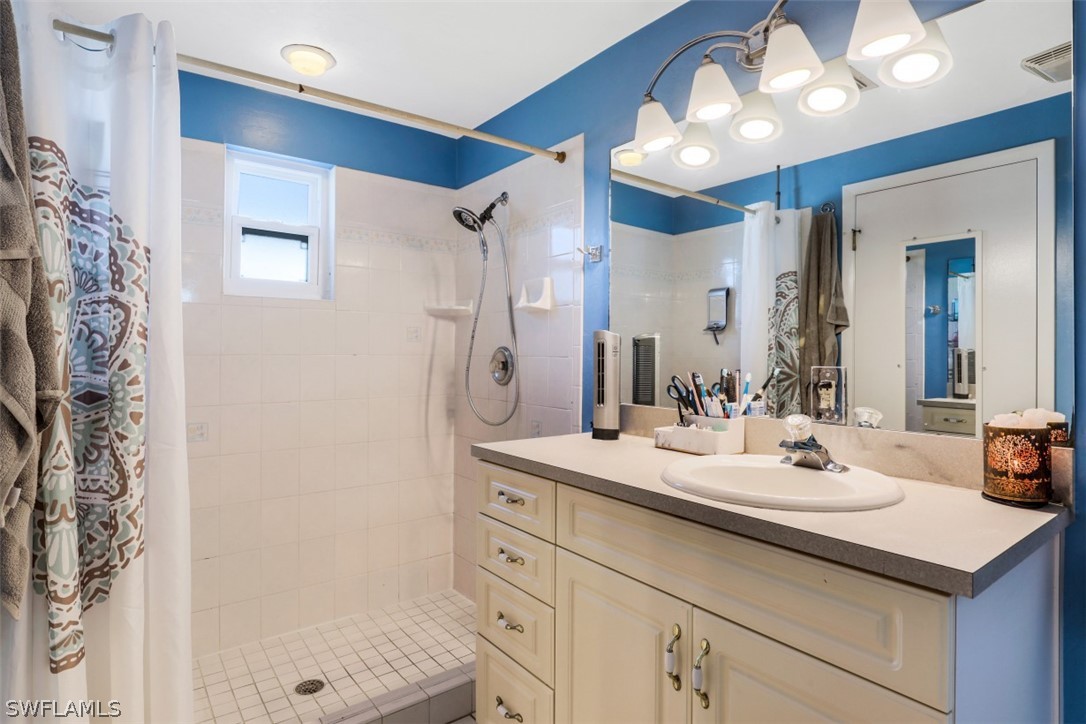 701 East 14th Street Lehigh Acres, FL 33972 - Photo 11 of 31 a bathroom with a sink a light fixture and a mirror