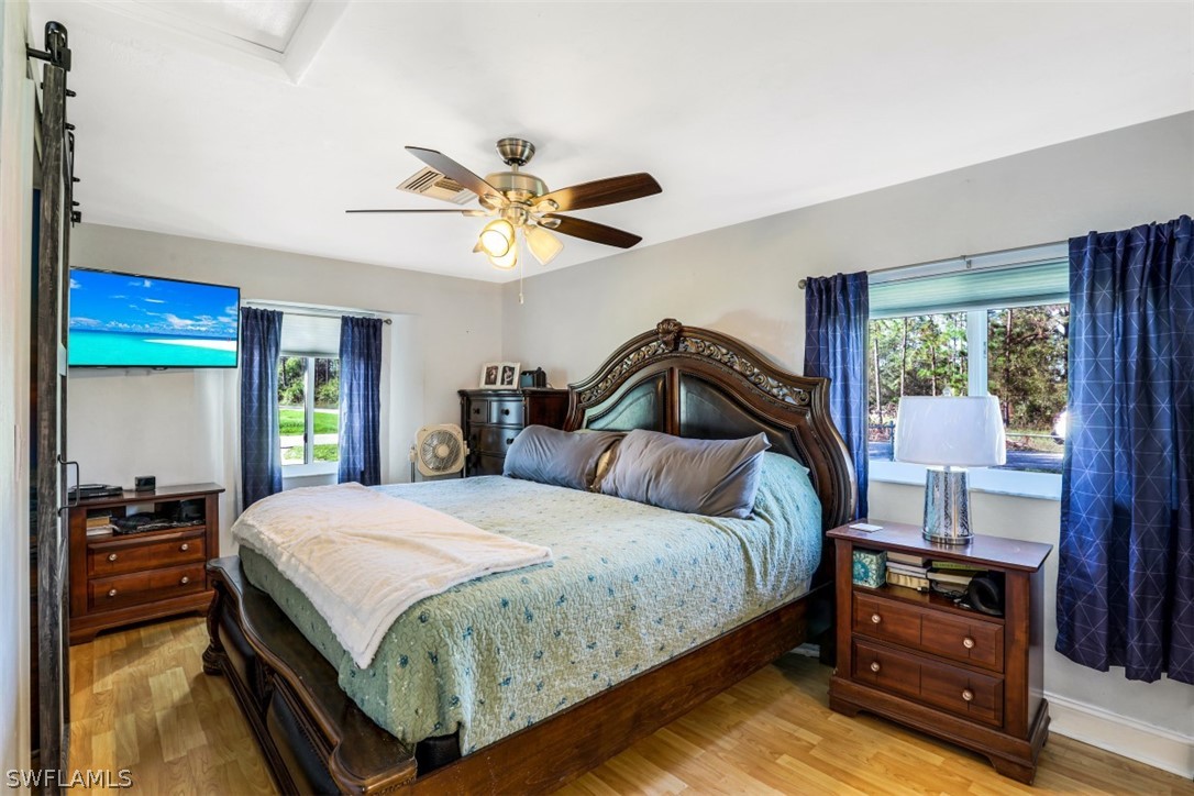 701 East 14th Street Lehigh Acres, FL 33972 - Photo 10 of 31 a bedroom with a bed and a chandelier