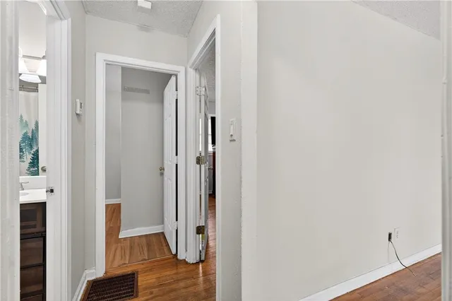 a view of a hallway with wooden floor and closet