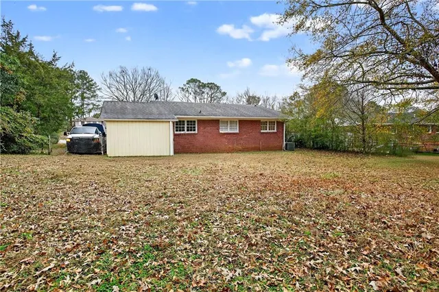 a view of a house with a garden and trees
