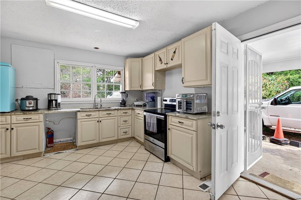 1742 Cardinal Road Hampton, GA 30228 - Photo 4 of 25 a kitchen with a white cabinets appliances and windows