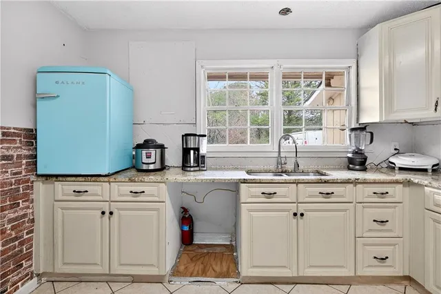 a kitchen with white cabinets and sink