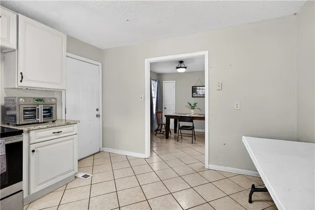 a kitchen with white cabinets and appliances