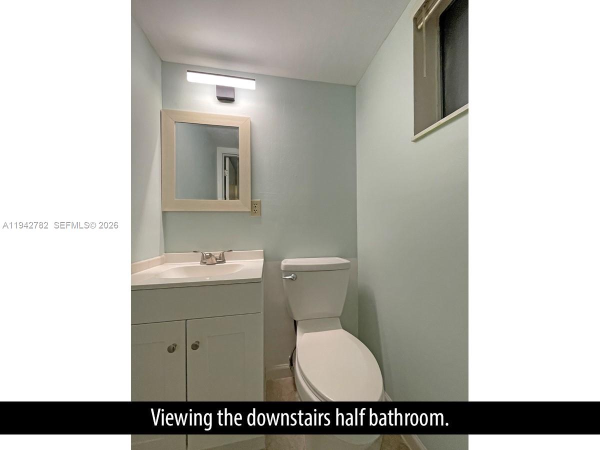 892 Southwest 9th St Circle, Unit 4 Boca Raton, FL 33486 - Photo 12 of 28 a bathroom with a toilet sink and mirror