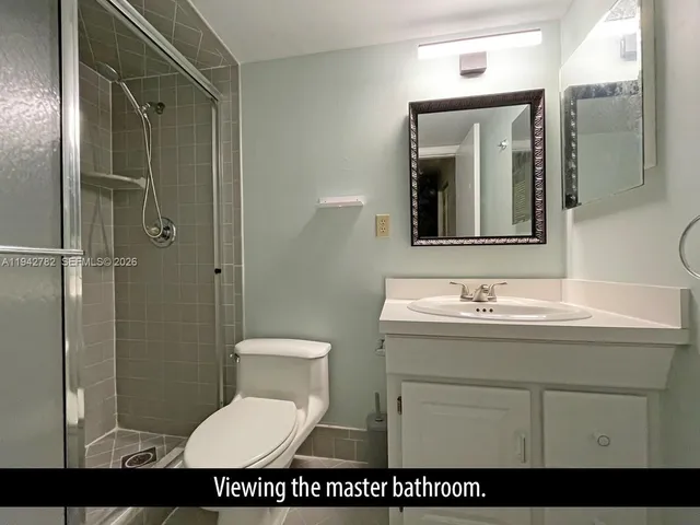 a bathroom with a sink shower and a mirror