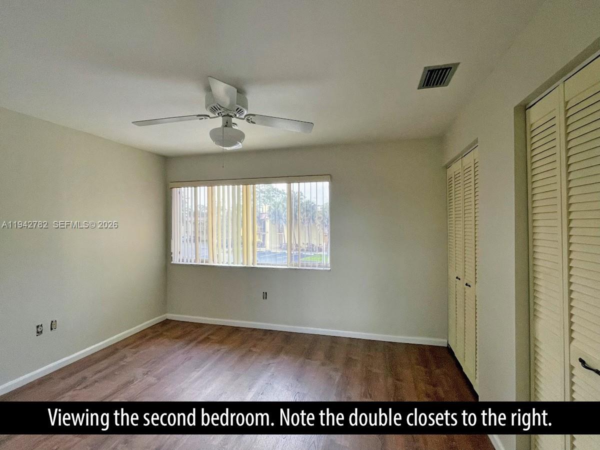 892 Southwest 9th St Circle, Unit 4 Boca Raton, FL 33486 - Photo 16 of 28 an empty room with wooden floor and windows