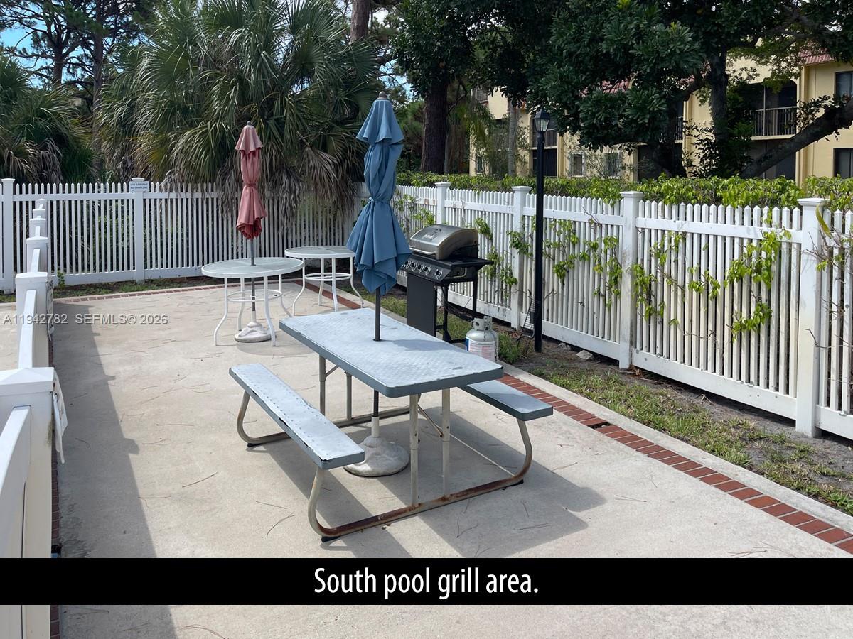 892 Southwest 9th St Circle, Unit 4 Boca Raton, FL 33486 - Photo 26 of 28 a view of a patio with a table and chairs