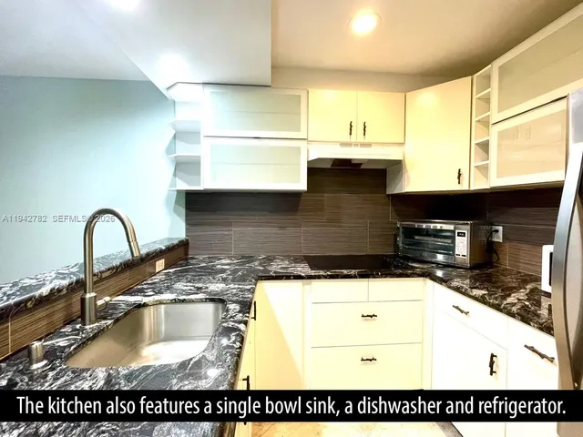 a view of a kitchen with granite countertop stove top oven and cabinets