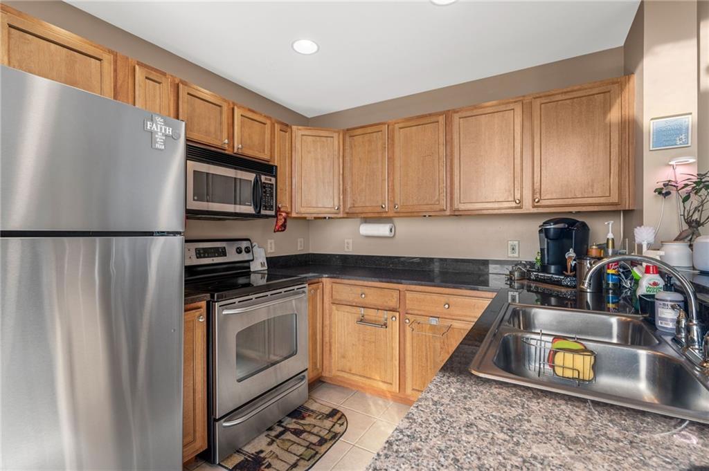 3040 Peachtree Road Northwest, Unit 605 Atlanta, GA 30305 - Photo 17 of 29 a kitchen with stainless steel appliances a stove a sink a refrigerator cabinets and a counter top space