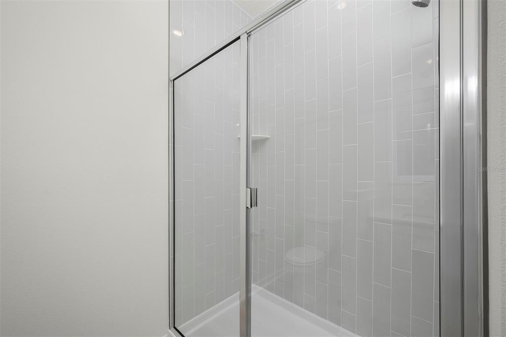 13288 Tula Loop Astatula, FL 34705 - Photo 14 of 23 a bathroom with a glass shower door