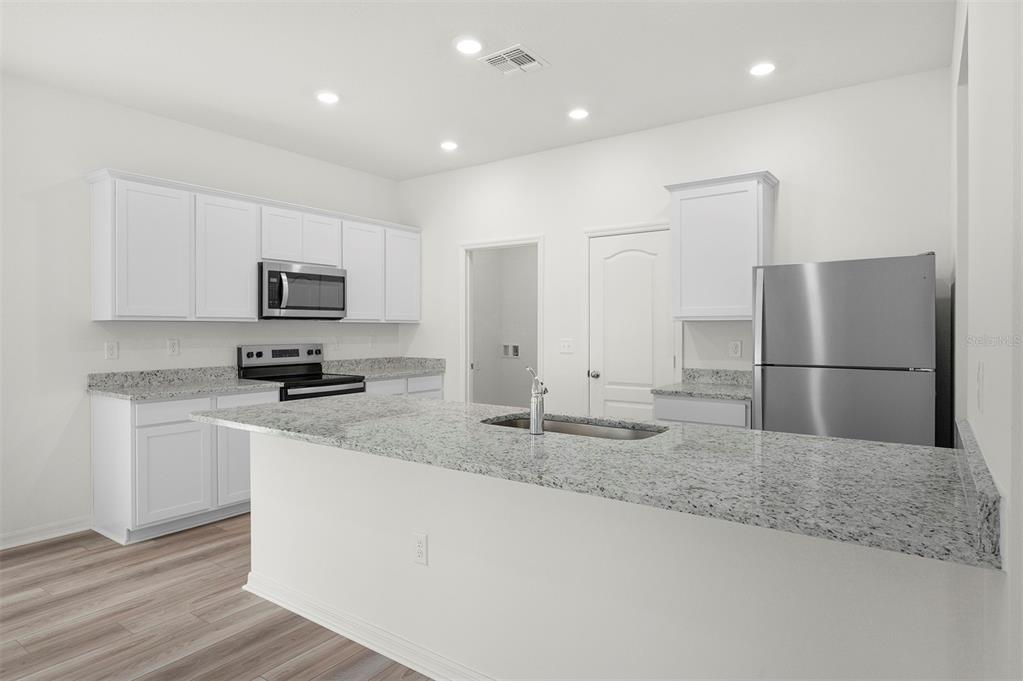 13288 Tula Loop Astatula, FL 34705 - Photo 3 of 23 a kitchen with kitchen island a sink stainless steel appliances and counter space